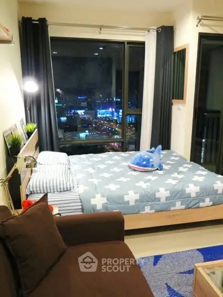 Cozy bedroom with city view, stylish decor, and comfortable furnishings.