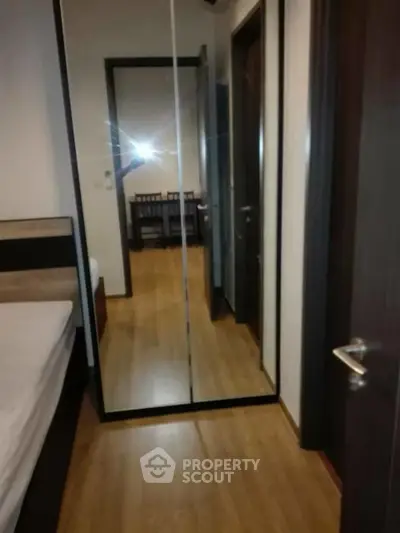Cozy bedroom with mirrored wardrobe and wooden flooring, perfect for modern living.