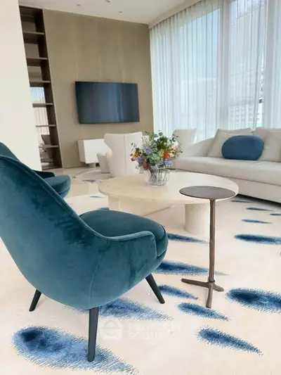 Luxurious modern living room with elegant furniture and large windows offering natural light.