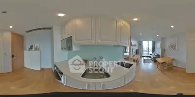 Modern open-layout kitchen with sleek cabinetry and spacious living area in a stylish apartment.