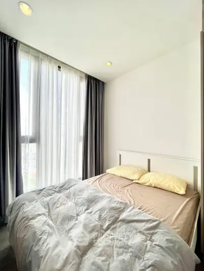 Cozy bedroom with large windows and natural light