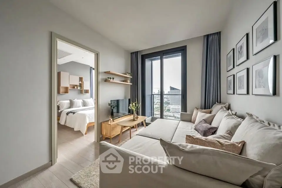 Modern living room with large windows and cozy furniture, adjacent to a stylish bedroom.