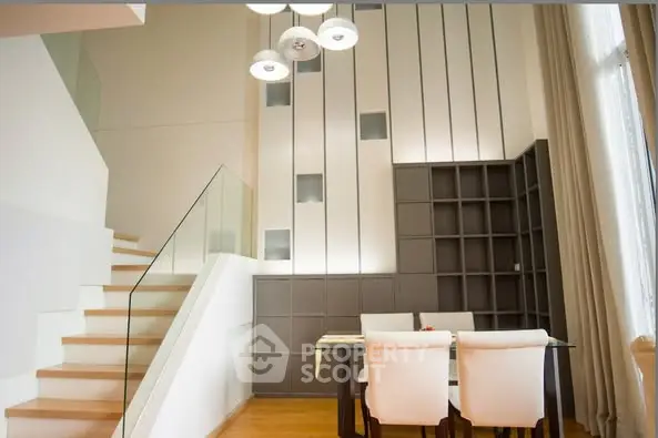 Modern dining area with elegant staircase and stylish lighting