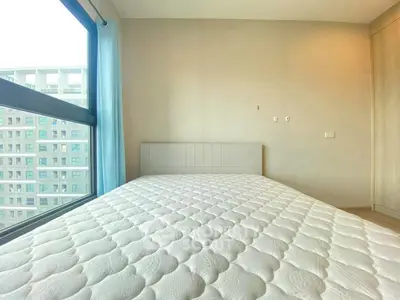 Spacious bedroom with large window and modern design in urban apartment