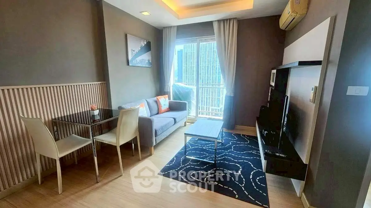 Modern living room with stylish decor and city view balcony in a high-rise apartment.