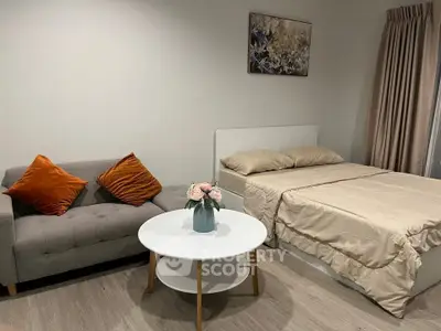 Cozy bedroom with stylish decor and comfortable seating area, perfect for relaxation.