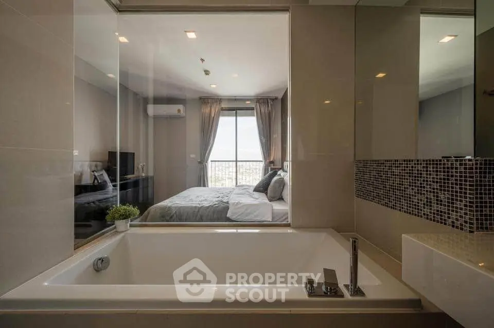 Luxurious bathroom with a view into a stylish bedroom, featuring a modern bathtub and elegant decor.