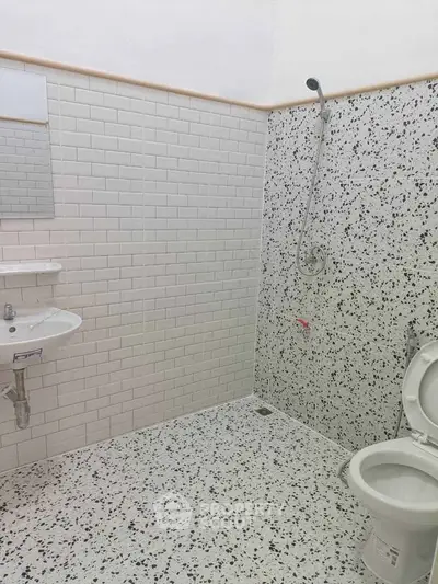 Modern bathroom with white subway tiles and terrazzo flooring