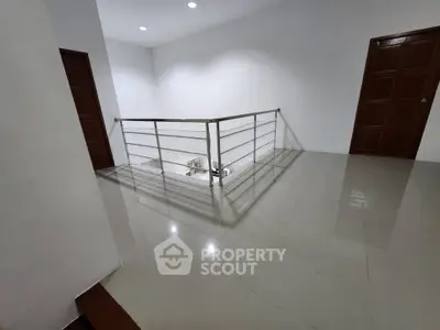 Spacious modern hallway with sleek railing and polished tile flooring