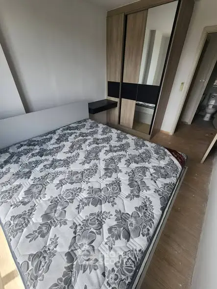 Modern bedroom with stylish wardrobe and floral-patterned bed in a cozy apartment.