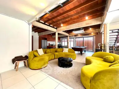 Spacious living room with unique yellow sofas and modern decor in open-plan layout.