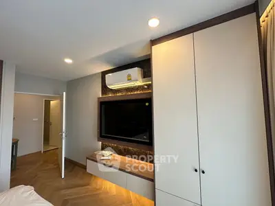 Modern living room with built-in TV unit and air conditioning, featuring elegant wood flooring and ambient lighting.