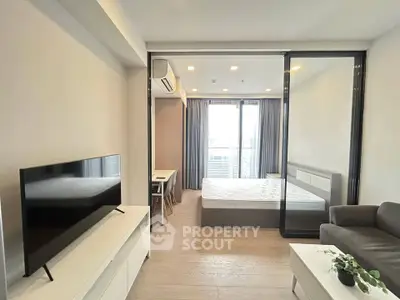 Modern studio apartment with sleek design and large windows offering ample natural light.