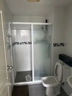 Modern bathroom with glass shower enclosure and sleek design.