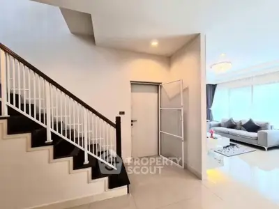 Elegant modern living room with staircase and natural light