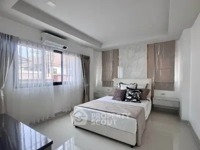Spacious modern bedroom with elegant decor and large windows for natural light.