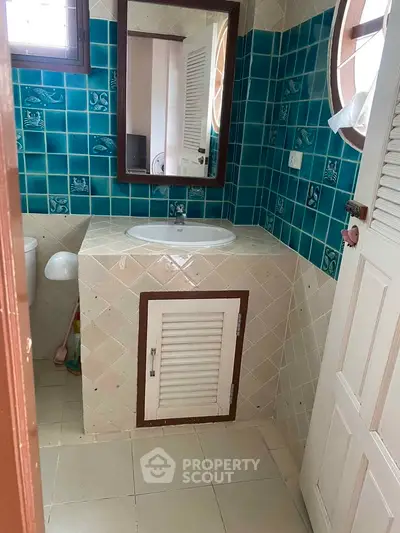 Charming bathroom with vintage tiles and unique window design, perfect for a cozy home ambiance.