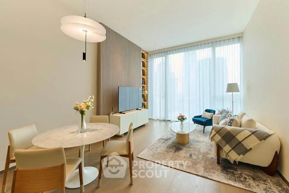 Elegant modern living room with stylish furniture and large windows offering city views.