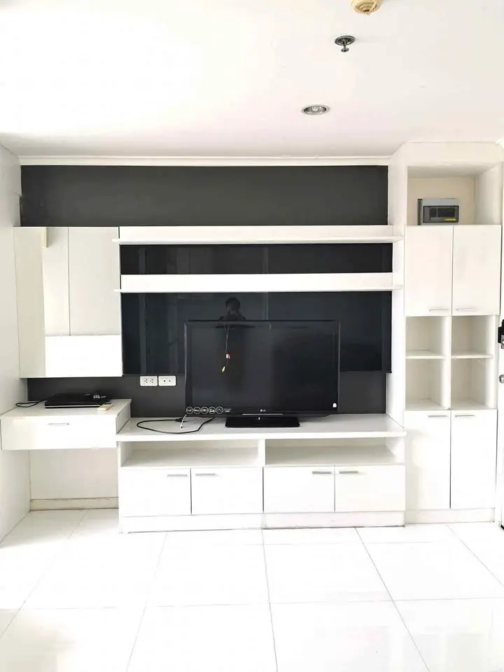 Modern living room with sleek white entertainment center and TV setup