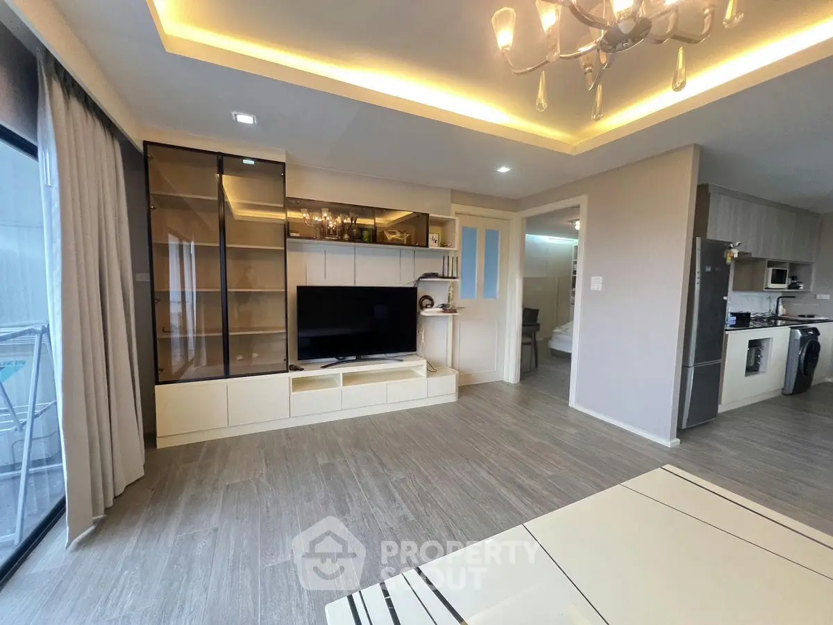 Modern living room with open kitchen, featuring sleek design and ample natural light.