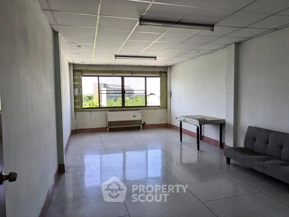 Spacious unfurnished room with large window and natural light