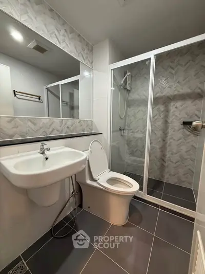 Modern bathroom with sleek shower and stylish tiles in contemporary apartment.