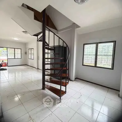Spacious interior with spiral staircase and large windows, perfect for modern living.