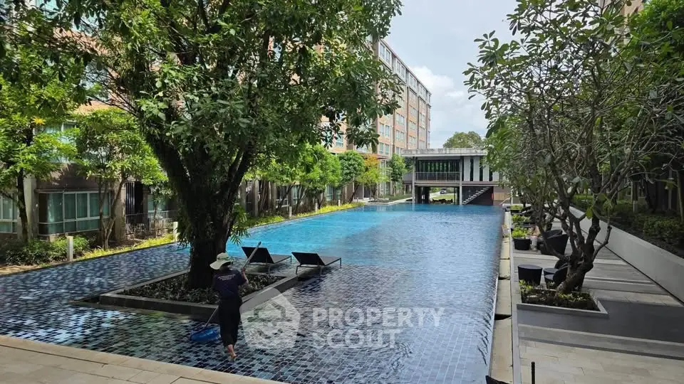 Luxurious apartment complex with stunning pool and lush greenery, perfect for relaxation and leisure.