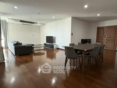 Spacious living room with modern furniture and wooden flooring in a luxury apartment.