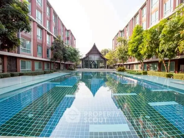 Luxurious apartment complex with stunning outdoor pool and lush greenery.