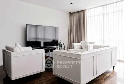 Elegant living room with modern furniture and large TV, featuring floor-to-ceiling windows and stylish decor.