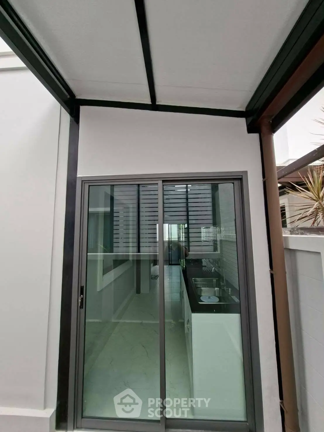 Modern kitchen with sleek design and sliding glass doors leading to outdoor space.