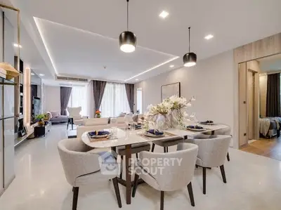 Luxurious open-plan living and dining area with elegant decor and modern lighting.