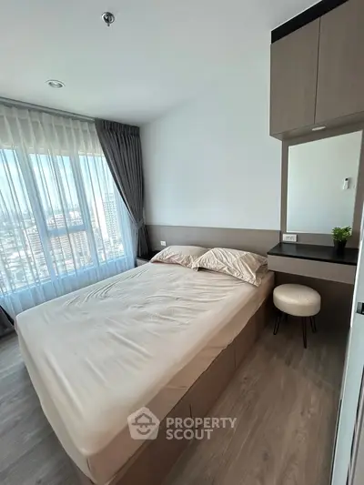 Modern bedroom with large window and stylish decor in high-rise apartment.