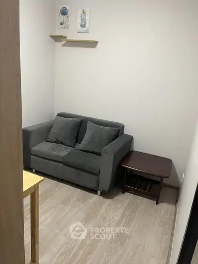 Cozy small living room with gray sofa and wooden table, ideal for compact spaces.