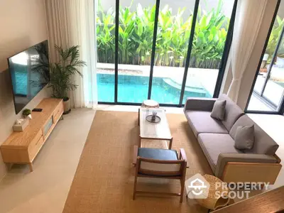 Luxurious living room with pool view, modern furniture, and floor-to-ceiling windows.