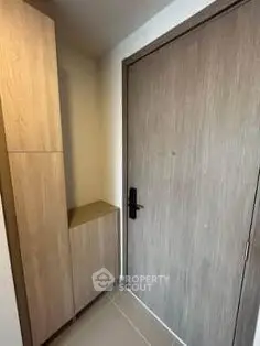 Modern apartment entrance with sleek wooden door and storage cabinet