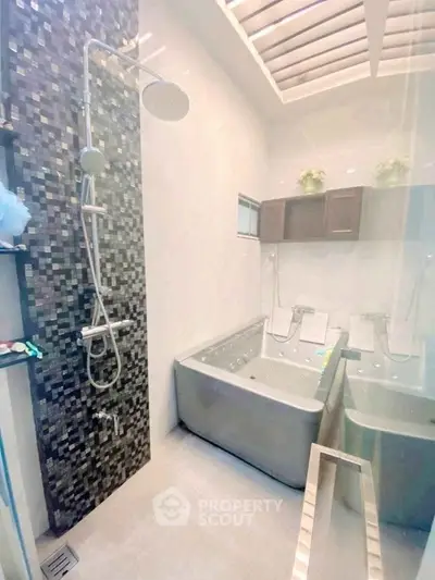 Luxurious bathroom with modern shower and jacuzzi tub under skylight