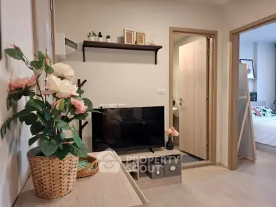 Cozy modern living room with TV and stylish decor, adjacent to a bedroom.