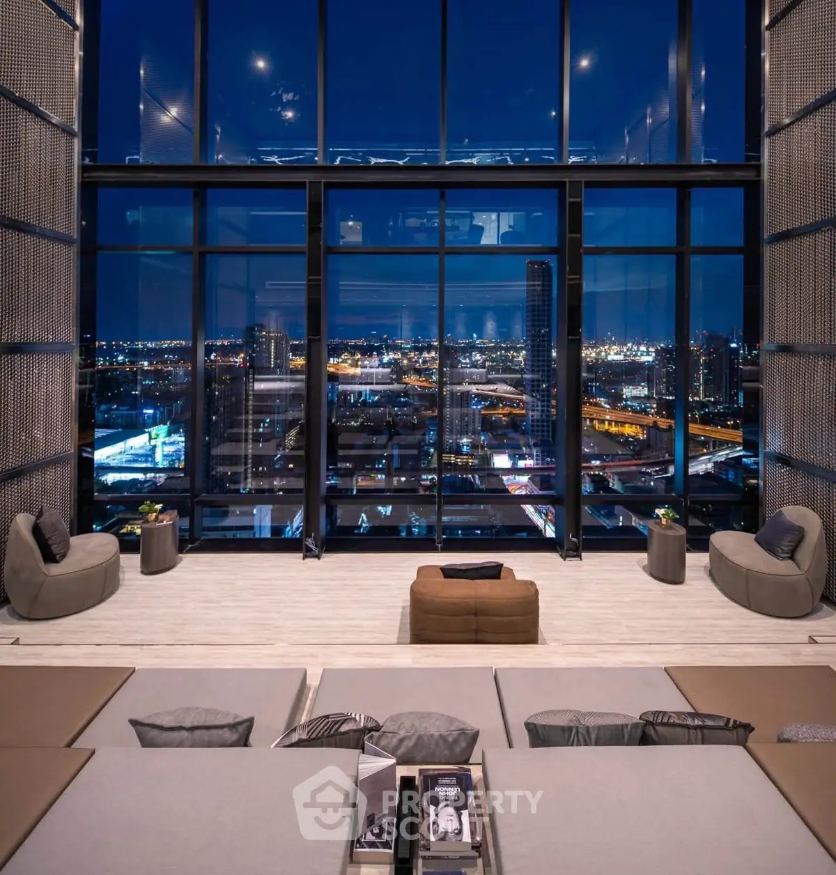 Luxurious high-rise living room with stunning cityscape view through floor-to-ceiling windows at night.