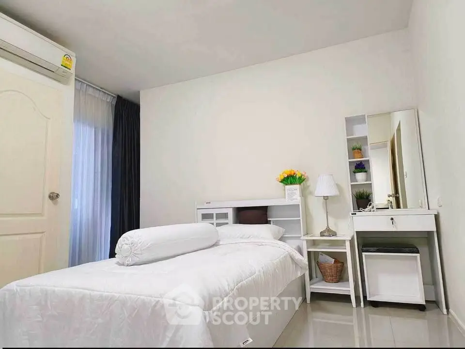 Cozy bedroom with modern decor and natural light, perfect for relaxation.