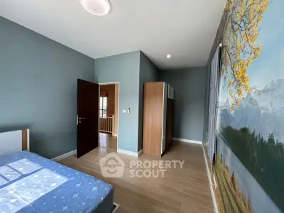Spacious bedroom with scenic wall mural and wooden flooring