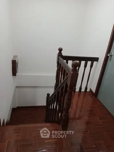 Elegant wooden staircase with polished handrails and parquet flooring