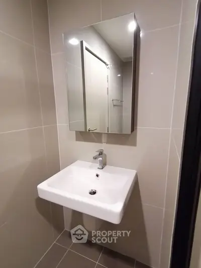 Modern bathroom with sleek sink and mirror in a minimalist design.