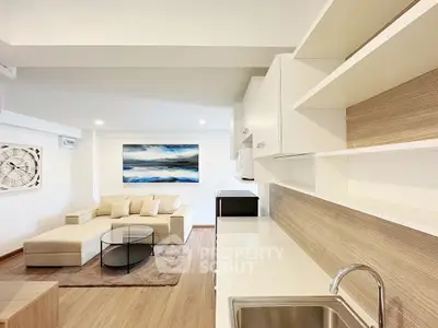 Modern living room with sleek kitchen, open layout, and stylish decor