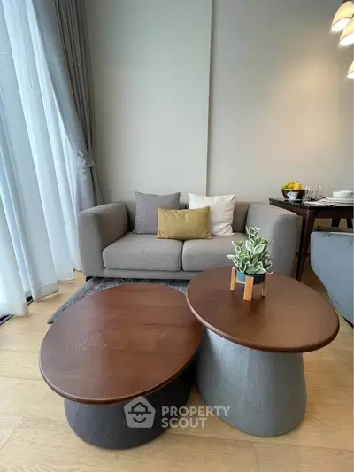Stylish modern living room with cozy sofa and elegant coffee tables, perfect for relaxation and entertaining.