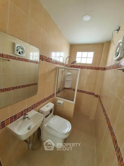 Compact bathroom with modern fixtures and tiled walls