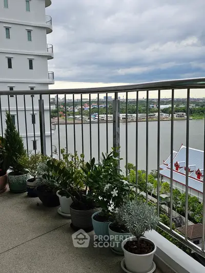 Spacious balcony with river view and potted plants in modern apartment