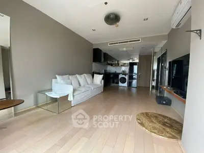 Spacious modern living room with open kitchen and sleek design in a contemporary apartment.