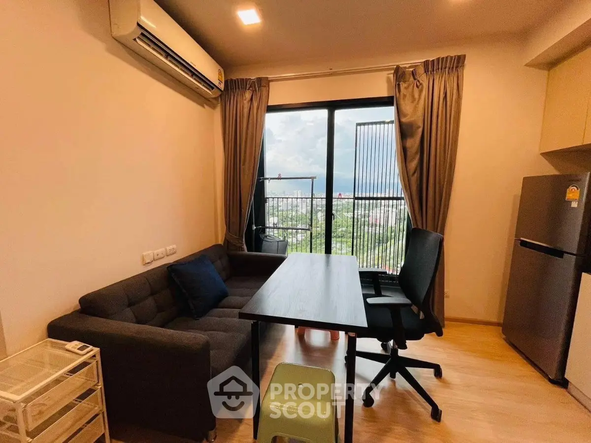 Modern living room with city view, featuring sleek furniture and large window.